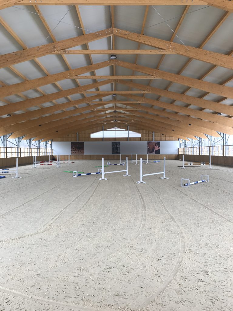 Manège couvert conçu pour offrir aux chevaux un espace d'entraînement plus frais pendant les périodes de fortes chaleurs.