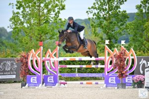 Cavalier et cheval franchissant un obstacle lors d’un parcours de saut d’obstacles